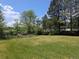 Expansive backyard featuring lush grass and mature trees, offering privacy and a serene outdoor space at 1251 Lee St, Lakewood, CO 80215