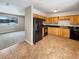 Kitchen with wood cabinets, black appliances, and tile flooring at 3569 W 89Th Ave, Westminster, CO 80031