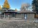 View of a brick home with a covered wooden deck and brick patio in the backyard at 2995 S Whiting Way, Denver, CO 80231