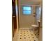 Tiled bathroom featuring shower, toilet, and wooden wall storage at 2995 S Whiting Way, Denver, CO 80231