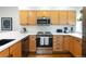 Modern kitchen with light wood cabinets, stainless steel appliances, and white countertops at 1415 E 16Th Ave # 1/2, Denver, CO 80218