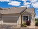 Charming tan townhouse with attached garage, neat landscaping, and sunny skies at 12335 E 2Nd Dr, Aurora, CO 80011