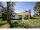 Backyard view of home with grey siding, chimney, sliding glass doors, and lush green grass at 6597 S State Highway 83, Franktown, CO 80116