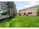 Spacious backyard featuring a well-maintained lawn, mature trees, and wooden deck at 5674 S Ingalls St, Littleton, CO 80123