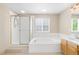 Bright bathroom featuring a separate shower and tub and light wood cabinets at 5674 S Ingalls St, Littleton, CO 80123