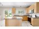 Kitchen with stone countertops, an island, stainless steel appliances and light wood cabinets at 5674 S Ingalls St, Littleton, CO 80123