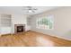 Bright living room with fireplace, hardwood floors, and views of the outdoor landscape at 5674 S Ingalls St, Littleton, CO 80123