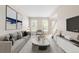 Inviting living room featuring a comfortable sofa, large windows, and modern decor at 5674 S Ingalls St, Littleton, CO 80123