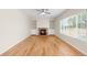 Spacious living room with hardwood floors, a cozy fireplace, and built-in bookshelves at 5674 S Ingalls St, Littleton, CO 80123