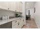 Modern butler's pantry with white cabinets, marble countertops, and stainless steel appliances at 5489 Country Club Dr, Larkspur, CO 80118