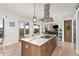 Gourmet kitchen with a marble island, stainless steel hood, and an adjacent outdoor deck at 5489 Country Club Dr, Larkspur, CO 80118