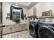 Well-lit laundry room with modern washer/dryer, neutral cabinets, and scenic view at 5489 Country Club Dr, Larkspur, CO 80118