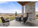 Stunning outdoor patio with stone fireplace, comfortable seating, and breathtaking views at 5489 Country Club Dr, Larkspur, CO 80118