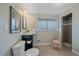 Bathroom with dark vanity, tile floor, toilet, and tiled shower in the background at 6482 S Cedar St, Littleton, CO 80120