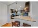Modern kitchen with granite countertops and dark cabinetry, open to the dining area at 6482 S Cedar St, Littleton, CO 80120