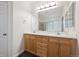 Bathroom with double sinks, wood cabinets, and a large mirror with vanity lighting at 179 N Prairie Falcon Pkwy, Brighton, CO 80601