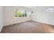Minimalist bedroom with natural light, neutral carpeting, and three windows at 179 N Prairie Falcon Pkwy, Brighton, CO 80601