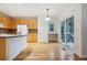 Bright kitchen with wooden cabinets, a breakfast bar, and hardwood floors at 179 N Prairie Falcon Pkwy, Brighton, CO 80601