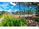 Exterior view of a community tennis court surrounded by a black chain-link fence and lush landscaping at 3161 Madison Ave # R313, Boulder, CO 80303