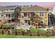Expansive two-story home featuring a large wood deck and backyard with a wooden fence and lush landscaping at 18340 W 85Th Dr, Arvada, CO 80007