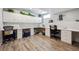Finished basement with craft and sewing tables, overhead cabinetry, and wood-look flooring at 18340 W 85Th Dr, Arvada, CO 80007