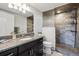Bathroom featuring granite countertop vanity with tile shower, flooring and decorative backsplash at 18340 W 85Th Dr, Arvada, CO 80007