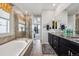 Bright bathroom boasts a soaking tub, glass shower, and double vanity with granite counters at 18340 W 85Th Dr, Arvada, CO 80007