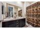 Well-lit bathroom with dual sinks, a large mirror, and a shower featuring a decorative curtain at 18340 W 85Th Dr, Arvada, CO 80007