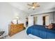 Bedroom features neutral carpet, ceiling fan, and walk in closet with an adjacent ensuite bathroom at 18340 W 85Th Dr, Arvada, CO 80007