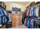 Walk-in closet contains neatly organized clothes, shelves, and a wooden dresser at 18340 W 85Th Dr, Arvada, CO 80007