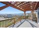 Covered deck with beautiful views of the surrounding landscape, featuring a wood pergola and deck railing at 18340 W 85Th Dr, Arvada, CO 80007