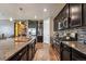 Well-appointed kitchen featuring granite countertops, stainless appliances, dark cabinetry, and hardwood floors at 18340 W 85Th Dr, Arvada, CO 80007