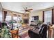 Cozy living room featuring leather sofas, a fireplace, hardwood floors, and access to an outdoor space at 18340 W 85Th Dr, Arvada, CO 80007