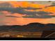 Scenic view of the mountains and fields under an orange sky, seen from the property at 18340 W 85Th Dr, Arvada, CO 80007