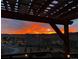 Beautiful sunset view of the surrounding landscape from the deck with wood pergola and outdoor lighting at 18340 W 85Th Dr, Arvada, CO 80007