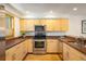 Well-lit kitchen featuring stainless steel oven, microwave and wooden cabinets, and granite countertops at 2938 Kalmia Ave # 6, Boulder, CO 80301