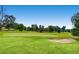 Beautiful green golf course with a sand trap and flag under a clear blue sky at 14001 E Marina Dr # 211, Aurora, CO 80014