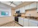 Functional kitchen with white cabinets, stainless steel appliances, and a pass-through to another room at 14001 E Marina Dr # 211, Aurora, CO 80014