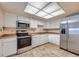 Well-lit kitchen with white cabinets, stainless steel appliances, and wood-look countertops at 14001 E Marina Dr # 211, Aurora, CO 80014