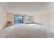 Bright living room featuring neutral carpeting, large windows, and a sliding glass door leading to a balcony at 14001 E Marina Dr # 211, Aurora, CO 80014