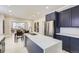 Modern kitchen with stainless steel refrigerator and large island with quartz countertop at 3532 N Vine St, Denver, CO 80205