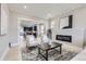 Bright living room featuring a modern fireplace, two chairs, and an open view into the kitchen at 3532 N Vine St, Denver, CO 80205