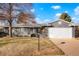 Single-story home with well-kept lawn, mature trees, and attached two car garage at 4751 S Xenia St, Denver, CO 80237