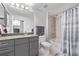Bathroom featuring vanity, toilet, and shower-tub combo with tiled walls and shower curtain at 1700 Bassett St # 820, Denver, CO 80202