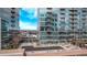 Modern high-rise building with community pool, lounge chairs, and outdoor dining under a beautiful blue sky at 1700 Bassett St # 820, Denver, CO 80202