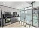 Contemporary kitchen with stainless appliances, black backsplash, and large window offering natural light at 1700 Bassett St # 820, Denver, CO 80202
