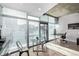 Open living area with large windows, concrete ceilings, and dining table located next to work space at 1700 Bassett St # 820, Denver, CO 80202