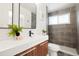 Modern bathroom featuring gray tiled walls, a sleek floating vanity, a unique mirror, and shower at 6087 S Elizabeth Way, Centennial, CO 80121