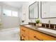 A modern bathroom with double sinks, wood vanity, and shower and tub combination at 6087 S Elizabeth Way, Centennial, CO 80121