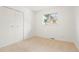 An empty bedroom with light walls and carpet, a closet, and bright lighting at 6087 S Elizabeth Way, Centennial, CO 80121